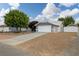 A gray single story home featuring a two-car garage, concrete driveway, and gravel landscaping at 5200 Wheatland Dr, Pahrump, NV 89061