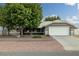 Charming home featuring a well-maintained front yard, a large tree, and a two-car garage at 5200 Wheatland Dr, Pahrump, NV 89061