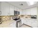 Bright kitchen showcasing white cabinets, granite counters, stainless steel appliances, and a tiled backsplash at 5200 Wheatland Dr, Pahrump, NV 89061