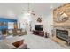 Comfortable living room featuring a stone fireplace, ceiling fan, and plush furnishings at 5200 Wheatland Dr, Pahrump, NV 89061