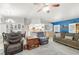 Open-concept living room with a stone fireplace, ceiling fan, and backyard access at 5200 Wheatland Dr, Pahrump, NV 89061