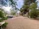 Large backyard featuring a small pond, mature trees, manicured landscaping, and decorative stone at 5381 Waving Sage Dr, Las Vegas, NV 89149