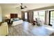 Spacious bedroom with decorative headboard, ceiling fan, and abundant natural light from windows and a glass door at 5381 Waving Sage Dr, Las Vegas, NV 89149
