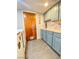 This stylish laundry room features beautiful blue cabinets, a butcher block countertop, and gray tile flooring at 5381 Waving Sage Dr, Las Vegas, NV 89149