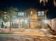 Night view of two-story home with well-lit exterior, two-car garage, and paver driveway at 5627 Spanish Valor Rd, Las Vegas, NV 89135