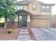 Charming two-story home with tan siding, stone accents, and a paved driveway at 5627 Spanish Valor Rd, Las Vegas, NV 89135