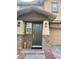 Close-up of front door with a covered porch, stone accents, and lantern sconces at 5627 Spanish Valor Rd, Las Vegas, NV 89135