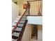 Staircase with wood and iron railing, carpeted steps, and decorative mirror at 5627 Spanish Valor Rd, Las Vegas, NV 89135