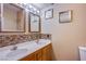 Bathroom featuring double sink vanity, decorative backsplash, and framed mirrors at 6274 Elderberry Wine Ave, Las Vegas, NV 89142