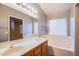Bathroom featuring a double sink vanity, mirror, blinds, and separate soaking tub at 6274 Elderberry Wine Ave, Las Vegas, NV 89142