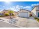 Charming single-story home features a two car garage, a well maintained lawn, and a tree in the front yard at 6274 Elderberry Wine Ave, Las Vegas, NV 89142