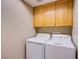 A convenient laundry room with washer and dryer and mounted storage cabinets at 6274 Elderberry Wine Ave, Las Vegas, NV 89142