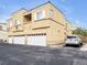 Exterior view of a residential building with garages, private balcony and parking at 6324 Desert Leaf St # 3, North Las Vegas, NV 89081