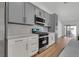 Close-up of the kitchen showcasing stainless steel appliances, white cabinets, and hardwood floors at 6664 Rutgers Dr, Las Vegas, NV 89156