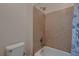 Bathroom featuring a tub/shower combo with beige tile and a toilet at 6750 Quapaw St, Las Vegas, NV 89149