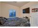 Bedroom featuring a dark comforter, carpet, window and mounted TV at 6750 Quapaw St, Las Vegas, NV 89149