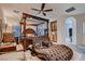 Bedroom with ceiling fan, a plush chaise lounge, and French doors leading to a balcony at 6750 Quapaw St, Las Vegas, NV 89149