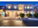 Charming two-story home featuring manicured landscaping and a two-car garage at twilight at 6750 Quapaw St, Las Vegas, NV 89149