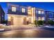 Charming two-story home featuring manicured landscaping and a two-car garage at twilight at 6750 Quapaw St, Las Vegas, NV 89149