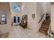 Inviting foyer featuring tile flooring, high ceilings, decorative chandelier and staircase leading to upper level at 6750 Quapaw St, Las Vegas, NV 89149
