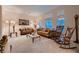 Spacious living room with ample natural light, carpet flooring, and comfortable seating at 6750 Quapaw St, Las Vegas, NV 89149