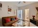 Cozy living room features a brown futon, glass-top coffee table and modern art at 6750 Quapaw St, Las Vegas, NV 89149