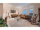 Bright living room featuring large windows, carpet flooring and traditional furnishings at 6750 Quapaw St, Las Vegas, NV 89149