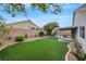Backyard featuring an artificial lawn and covered patio at 679 Riverband Pl, Henderson, NV 89052