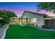 Lovely backyard featuring an artificial lawn, landscaping, and a covered patio at 679 Riverband Pl, Henderson, NV 89052