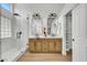 Well-lit bathroom with a double vanity, a glass-enclosed shower, and built in closet at 679 Riverband Pl, Henderson, NV 89052