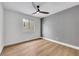 Bright bedroom features wood flooring, a ceiling fan, and a window at 679 Riverband Pl, Henderson, NV 89052