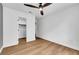 Well-lit bedroom with wood floors and open closet featuring visible shelving at 679 Riverband Pl, Henderson, NV 89052