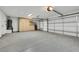 Spacious garage with epoxy flooring, storage cabinets, and an overhead garage door at 679 Riverband Pl, Henderson, NV 89052