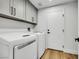Modern laundry room with front loading washer and dryer, overhead cabinets, and sleek design at 679 Riverband Pl, Henderson, NV 89052