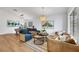 Open concept living room and dining area with modern furnishings, hardwood floors, and natural light at 679 Riverband Pl, Henderson, NV 89052
