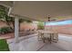 Covered patio features a ceiling fan and outdoor dining set for entertaining at 679 Riverband Pl, Henderson, NV 89052