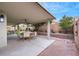 Relaxing covered patio with outdoor dining set and lush landscaping at 679 Riverband Pl, Henderson, NV 89052