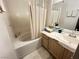 Clean, neutral bathroom boasts a soaking tub with shower, a vanity with storage and a plush rug at 698 S Racetrack Rd # 322, Henderson, NV 89015