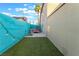 Cozy backyard with artificial grass, an outdoor hot tub, and a brightly painted accent wall at 7018 Berkshire Pl, Las Vegas, NV 89147