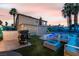 Spacious backyard featuring a pool, a grilling station, a fire pit, and cozy seating for relaxation and entertainment at 7018 Berkshire Pl, Las Vegas, NV 89147