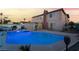 Private backyard featuring a sparkling pool with slide, lush greenery, and a charming patio area at 7018 Berkshire Pl, Las Vegas, NV 89147
