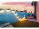 Private outdoor area with artificial turf, a hot tub, and decorative lighting along a blue brick wall at 7018 Berkshire Pl, Las Vegas, NV 89147