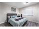Bedroom features wood floors, bed with blue comforter, and art at 7018 Berkshire Pl, Las Vegas, NV 89147