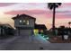 Charming two-story home with a large driveway, well-manicured lawn, and beautiful landscaping at twilight at 7018 Berkshire Pl, Las Vegas, NV 89147