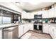 The kitchen features stone countertops, stainless steel appliances, and white cabinets offering a modern design at 7018 Berkshire Pl, Las Vegas, NV 89147