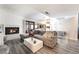 The living room features a white brick fireplace, plush sectional couch, and plank flooring, adding charm and comfort at 7018 Berkshire Pl, Las Vegas, NV 89147