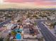 Residential neighborhood aerial view featuring swimming pools and landscaping with a city skyline in the distance at 7018 Berkshire Pl, Las Vegas, NV 89147