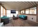 Enclosed patio features a turquoise sofa and chairs, with a tv and barstools at 7018 Berkshire Pl, Las Vegas, NV 89147