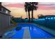 Sparkling pool and a diving board, surrounded by lush landscaping and a privacy fence with decorative lighting at 7018 Berkshire Pl, Las Vegas, NV 89147