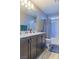 This bathroom features dual sinks, a shower with a curtain and tiled floors at 7175 Steubling Glen St, North Las Vegas, NV 89084